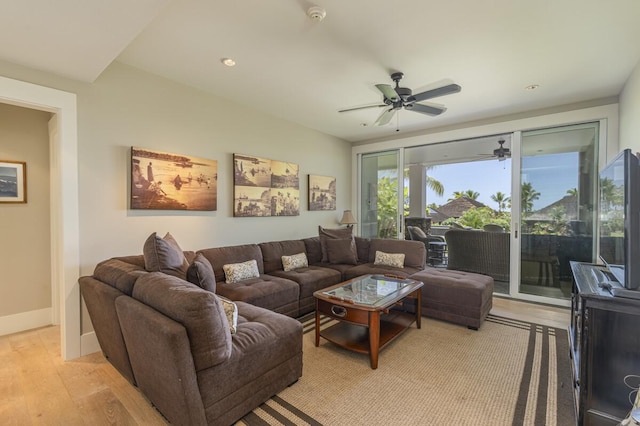 living room featuring ceiling fan, light wood-type flooring, and baseboards