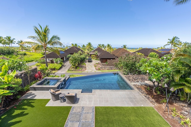 view of pool with a lawn, a patio area, and an in ground hot tub