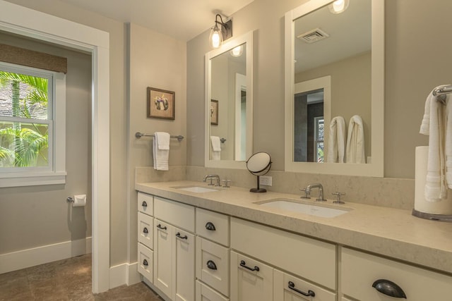 full bath featuring visible vents, a sink, baseboards, and double vanity