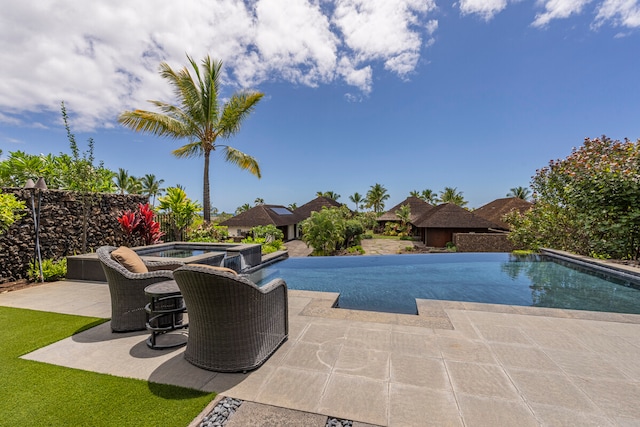 view of pool with an in ground hot tub and a patio