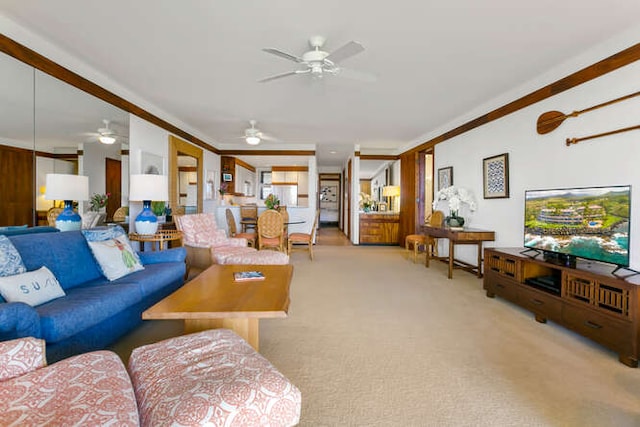 carpeted living room with ornamental molding and ceiling fan