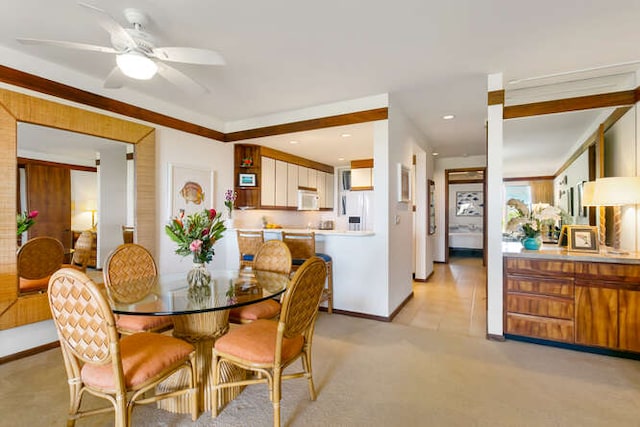 dining area featuring light colored carpet and ceiling fan