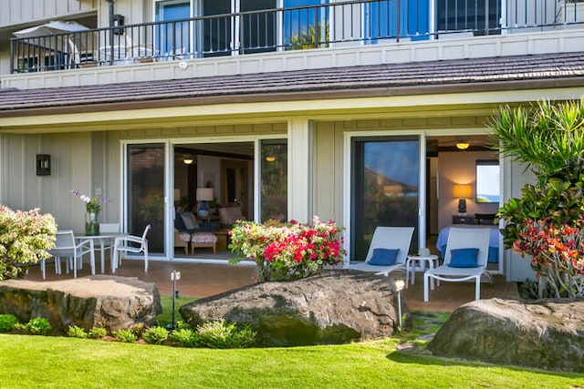 back of property with a balcony and a patio