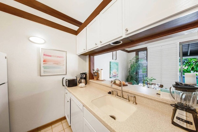 kitchen with sink, light tile patterned floors, white appliances, and white cabinetry