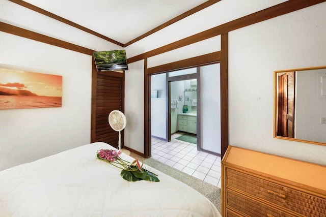 tiled bedroom featuring ensuite bath and ornamental molding