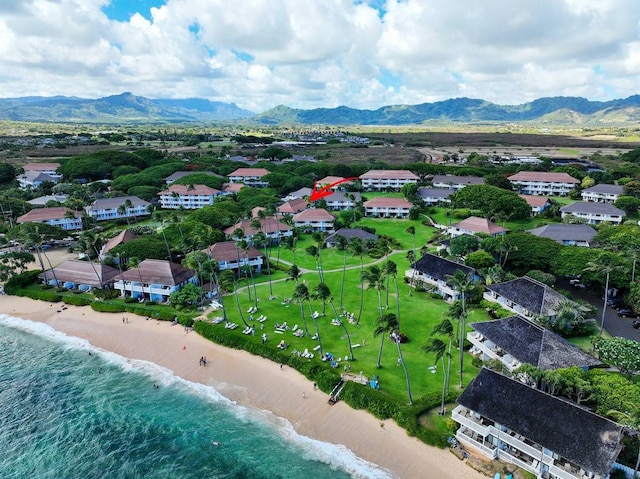 drone / aerial view featuring a view of the beach and a water and mountain view