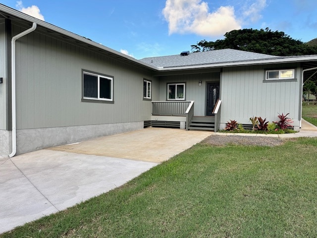 back of property featuring covered porch and a yard