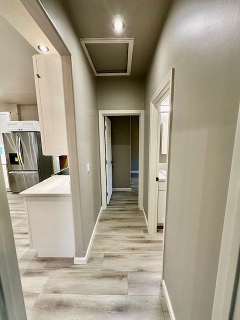 hall with light wood-type flooring, baseboards, and recessed lighting