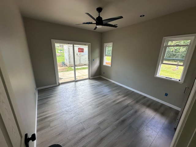 empty room with light wood-style flooring, baseboards, and ceiling fan