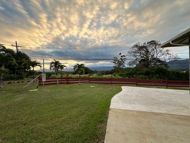 yard at dusk with fence and a patio