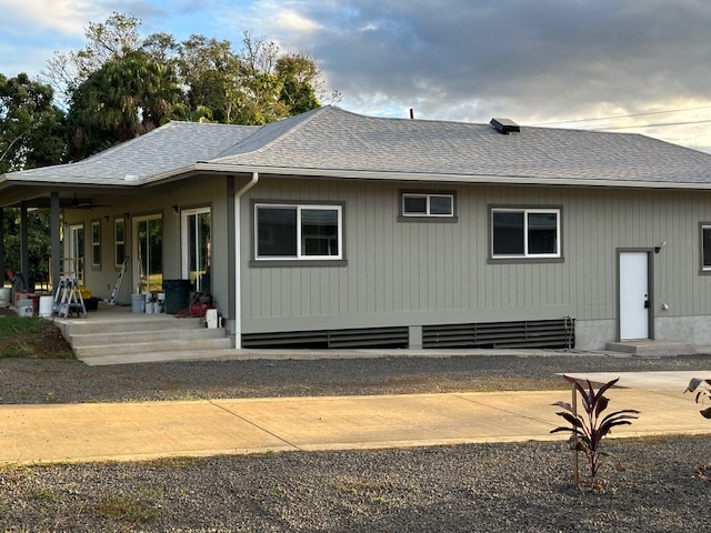 rear view of house with roof with shingles