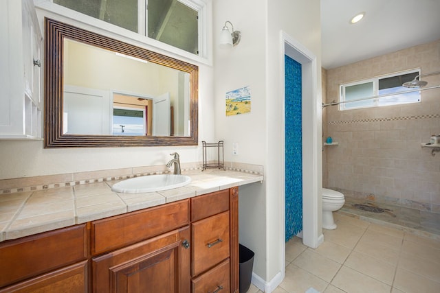 bathroom featuring recessed lighting, tiled shower, tile patterned floors, toilet, and vanity