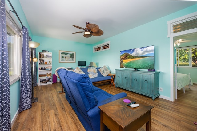 living room featuring ceiling fan, wood finished floors, and baseboards