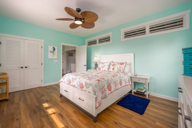 bedroom featuring dark wood-style floors, baseboards, a ceiling fan, and a closet