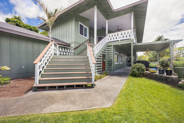 view of exterior entry with a yard and ceiling fan