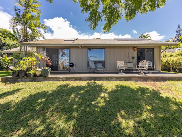 rear view of house featuring a patio area and a lawn