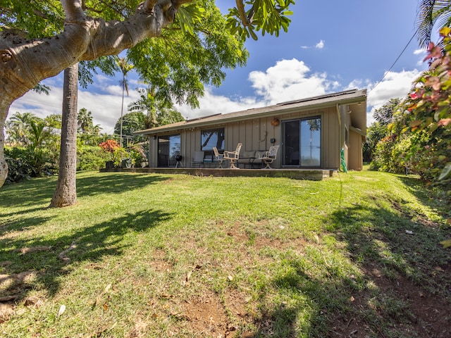 rear view of property with a lawn