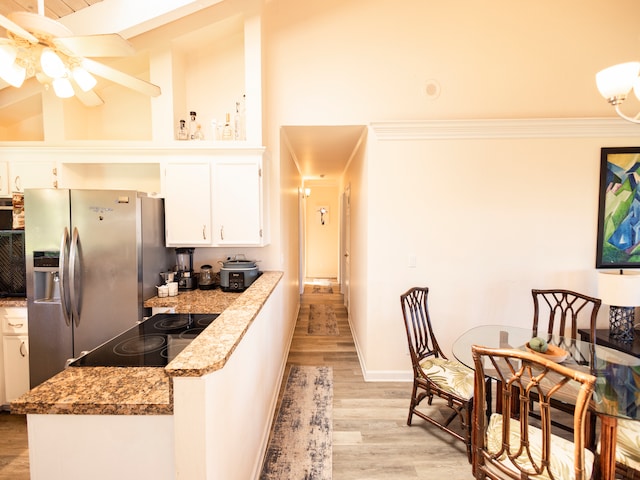 kitchen with stainless steel fridge, white cabinetry, light stone countertops, ceiling fan, and light hardwood / wood-style floors