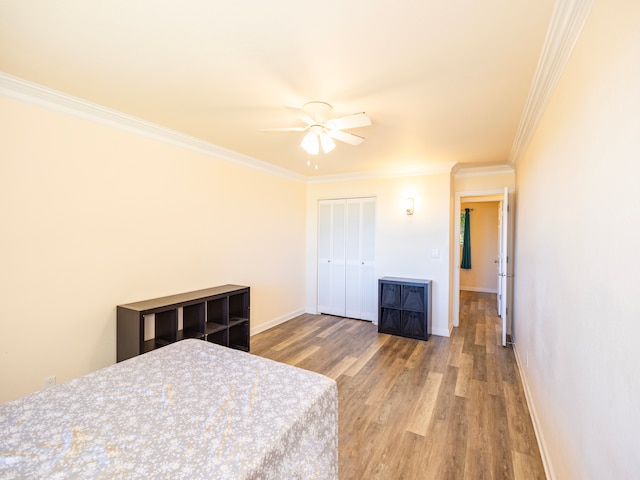 bedroom featuring a closet, ceiling fan, hardwood / wood-style flooring, and ornamental molding