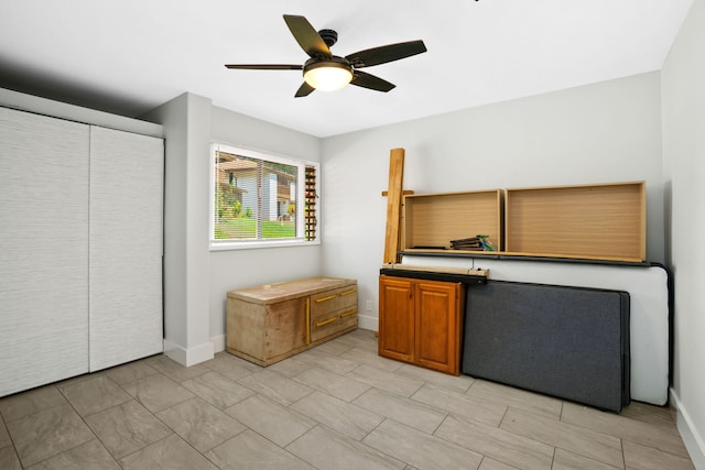 interior space with ceiling fan and a closet