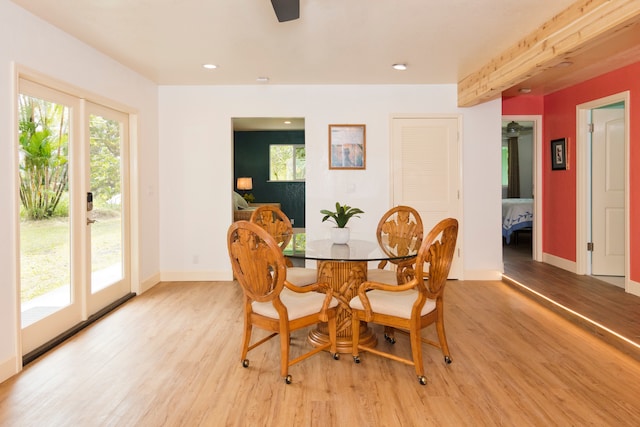 dining space with beamed ceiling and light hardwood / wood-style flooring