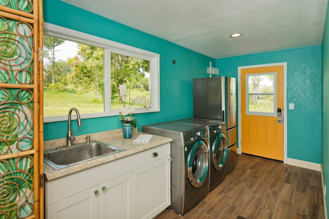 laundry room with sink, cabinets, dark hardwood / wood-style flooring, and washer and clothes dryer