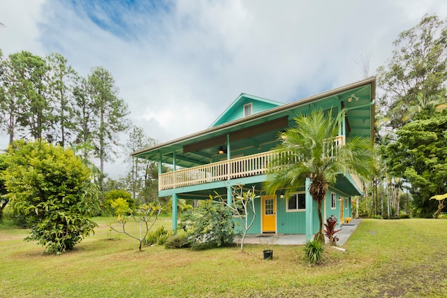 back of house featuring ceiling fan, a lawn, and a porch