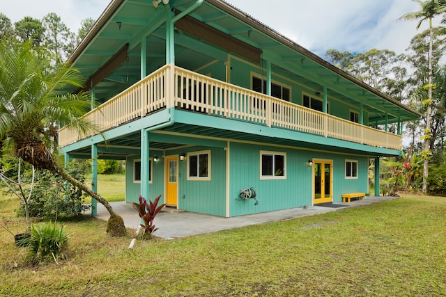 back of property featuring a balcony, a yard, and a patio