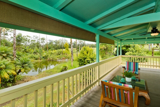 wooden deck featuring a water view and ceiling fan