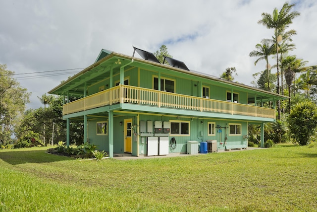 rear view of property featuring a yard, cooling unit, and a wooden deck
