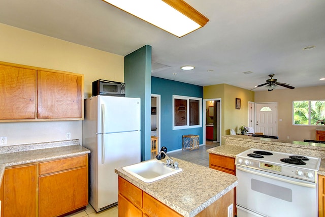 kitchen featuring light tile patterned floors, white appliances, sink, ceiling fan, and a kitchen island