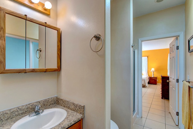 bathroom featuring a shower with door, vanity, and tile patterned flooring