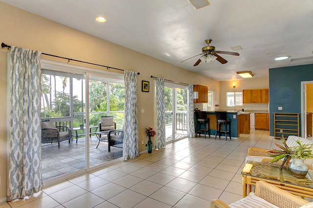 living room with light tile patterned floors, ceiling fan, and a wealth of natural light