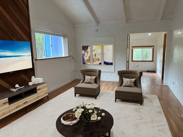 living room with lofted ceiling with beams, a healthy amount of sunlight, and hardwood / wood-style floors