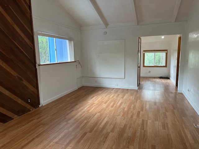 empty room with hardwood / wood-style flooring and lofted ceiling with beams