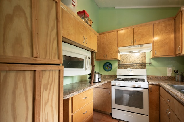 kitchen featuring dark wood-type flooring, white appliances, and vaulted ceiling