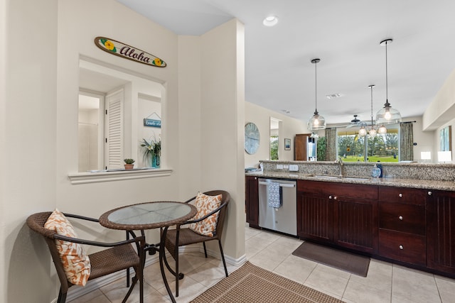 kitchen with light stone counters, sink, light tile patterned floors, decorative light fixtures, and dishwasher