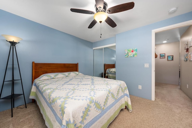 bedroom featuring a closet, ceiling fan, and light carpet