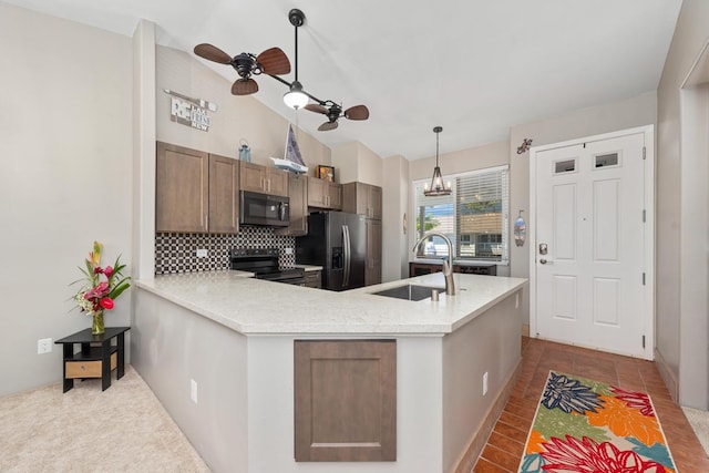 kitchen with hanging light fixtures, stainless steel appliances, sink, and kitchen peninsula