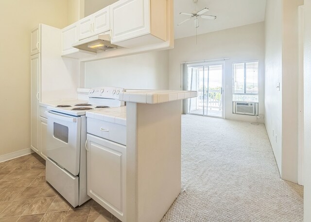 kitchen with tile counters, white cabinetry, light colored carpet, ceiling fan, and white range with electric cooktop