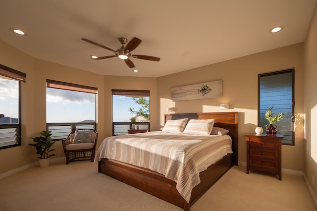 bedroom with ceiling fan, light colored carpet, and multiple windows