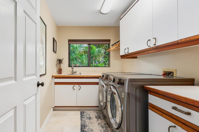 laundry room with cabinets, sink, independent washer and dryer, and light tile patterned floors