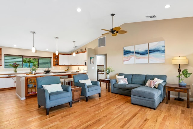 living room featuring ceiling fan, light hardwood / wood-style flooring, and high vaulted ceiling