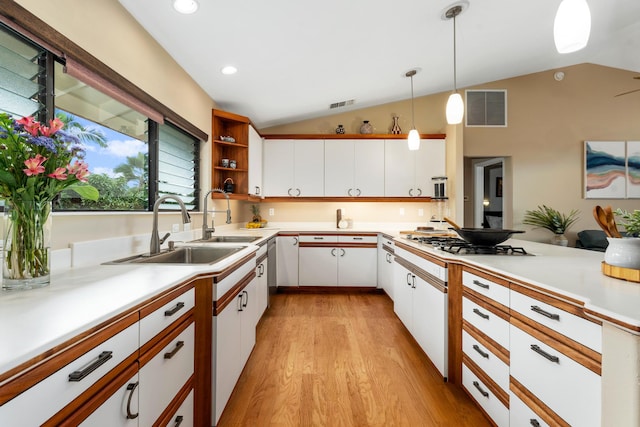 kitchen featuring hanging light fixtures, white cabinetry, and vaulted ceiling