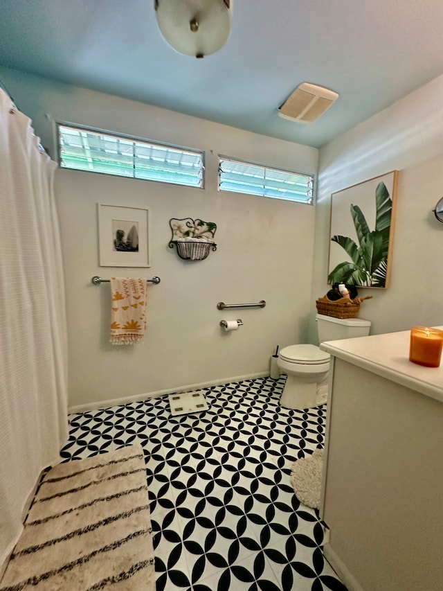 bathroom with a wealth of natural light, vanity, and toilet