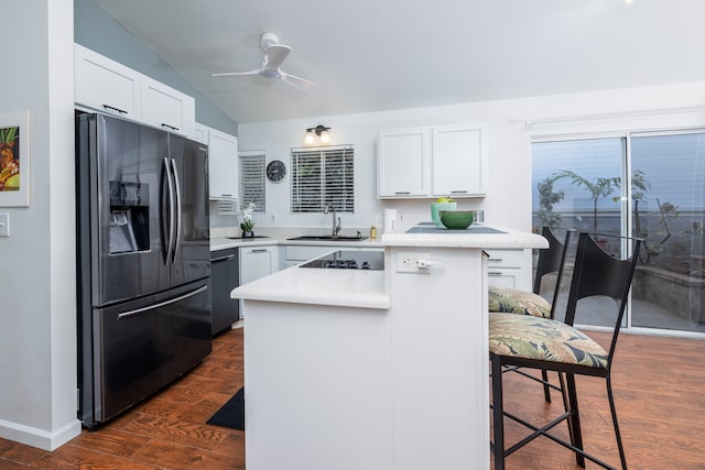 kitchen featuring lofted ceiling, a kitchen island, appliances with stainless steel finishes, and dark hardwood / wood-style flooring