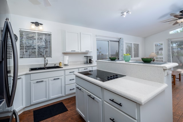 kitchen with vaulted ceiling, white cabinetry, stainless steel refrigerator, black electric cooktop, and ceiling fan