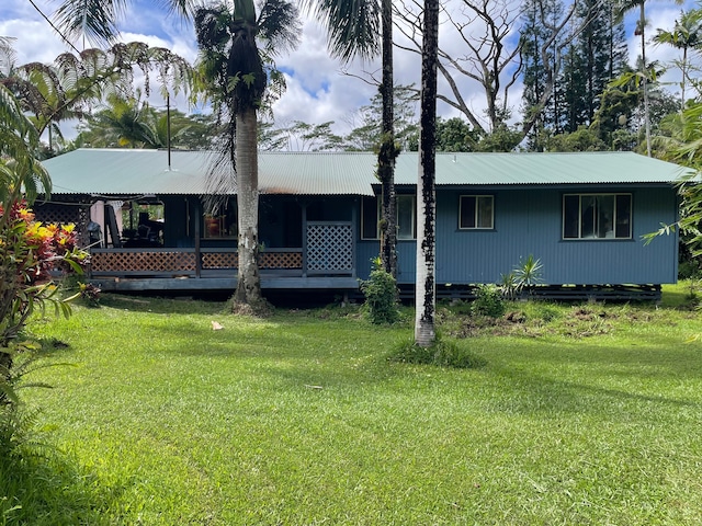 rear view of property featuring a yard and covered porch