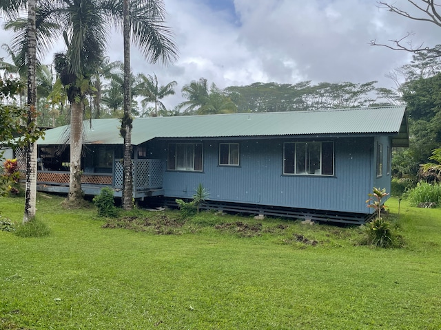 rear view of property featuring a lawn