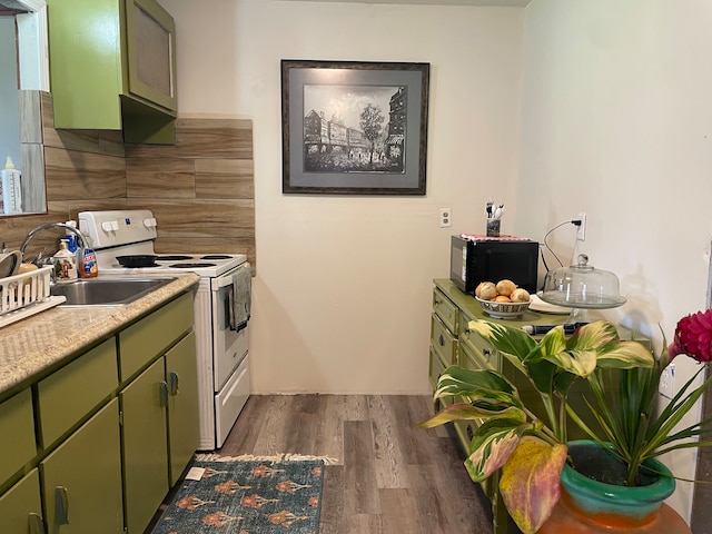 kitchen with backsplash, dark wood-type flooring, sink, green cabinetry, and electric stove